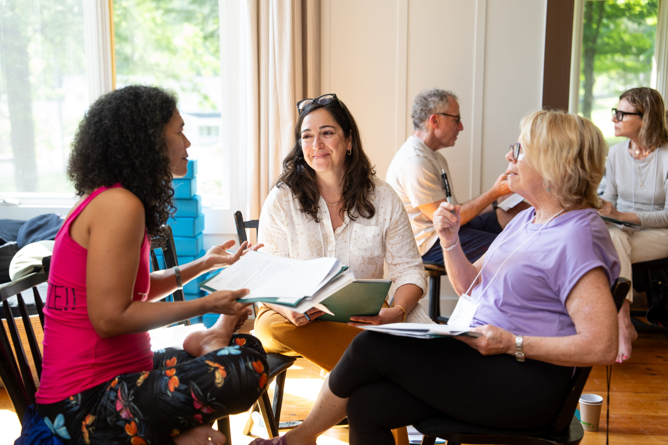 woman with short brown hair wearing a blue shirt and glasses leading a discussion